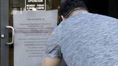 FILE - In this March 26, 2020 file photo a man takes a photo of a sign advising that the Employment Development Department is closed due to coronavirus concerns, in San Francisco. A review of California&#039;s unemployment agency has found its productivit