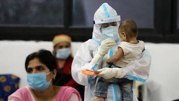 A medical worker in personal protective equipment (PPE) plays with a child of woman recovering inside a quarantine centre for the coronavirus disease (COVID-19) patients amidst the spread of the disease at an indoor sports complex in New Delhi, India, Sep
