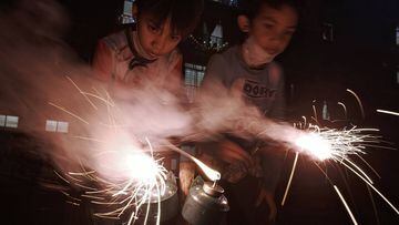 KUALA LUMPUR, MALAYSIA - MAY 23:  - Two Muslim boys light up a pair of firecrackers on the eve of Eid al-Fitr on May 23 2020 in Kuala Lumpur, Malaysia. Under the new normal, congegrations and visits are discouraged, and families have to celebrate one of t