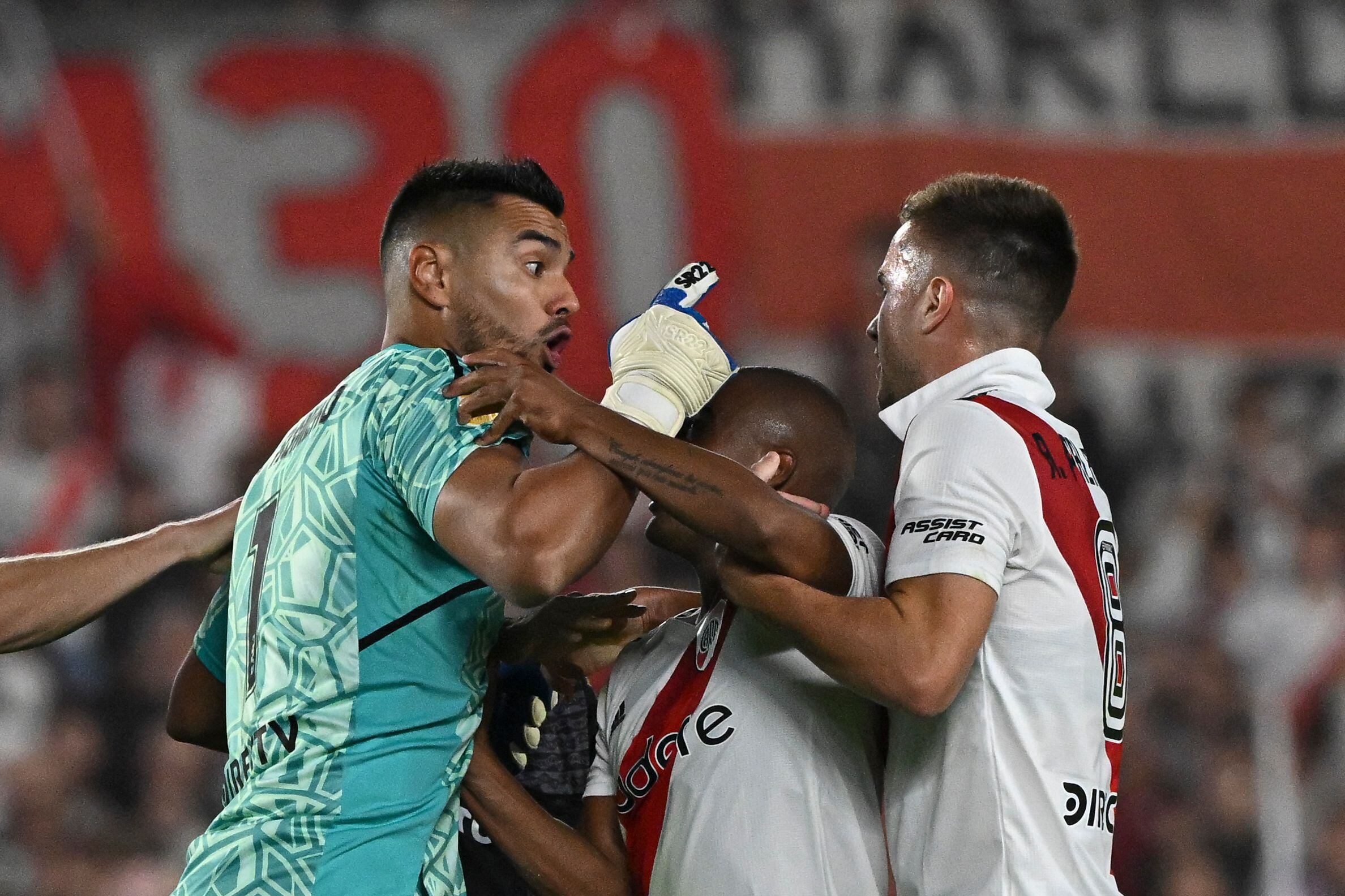 Boca Juniors' goalkeeper Sergio Romero (L) argues with River Plate's midfielder Agustin Palavecino (R) and midfielder Nicolas De La Cruz (C) after incidents following River Plate's penalty goal during their Argentine Professional Football League Tournament 2023 match at El Monumental stadium in Buenos Aires on May 7, 2023. (Photo by Luis ROBAYO / AFP)
